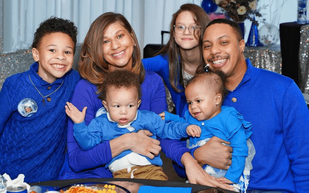 Event photography: smiling family of six in matching royal blue sweaters at a celebration